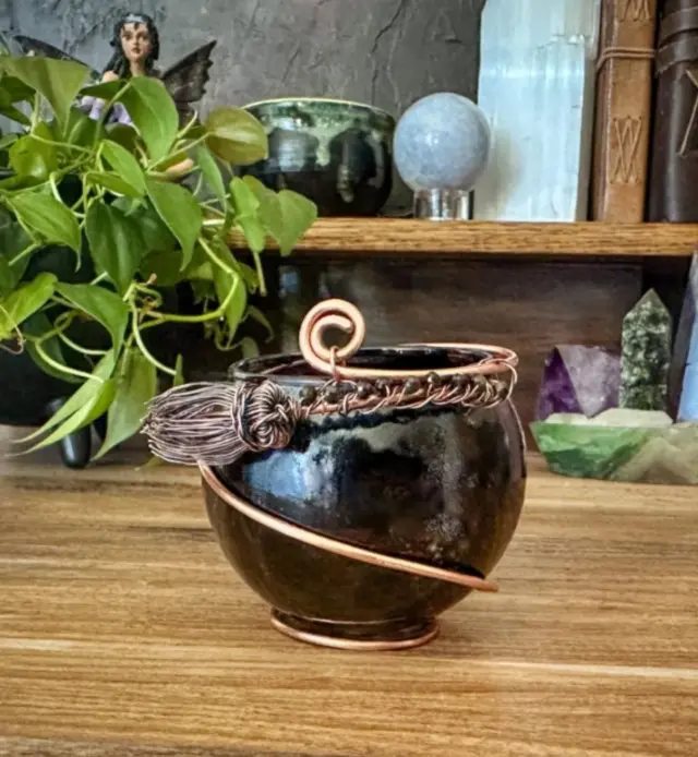 Enchanted Flame Spell Candleholder for Banishing. 

This deep black candleholder features a handcrafted broomstick charm wrapped with protective black obsidian crystals-known for their truth-revealing, boundary-setting energy. The broom is a powerful symbol of purification, sweeping away negativity and clearing space for growth. 

This piece is perfect for rituals of release, shadow work, or cord cutting-especially during the waning or dark moon. 

Magickal Focus: Banishing, Cord Cutting, Energetic Clearing, Protection

Use this spell candleholder in rituals where you are ready to let go of unhealthy ties, emotional patterns, fear, grief, or past wounds. Light your candle with intention and visualize the flamne burning through the cords that hold you back, while the charm and crystal do their sacred work. 

This and many other magical creations in the shop, link in bio. 

#herenchantedcreations #everydaywitchcraft #everydaymagic #magicalcreations #magicalsolutions #makingmagic #makeeverydaymagic #magicaltools #candleholders #banishing #ritualtools