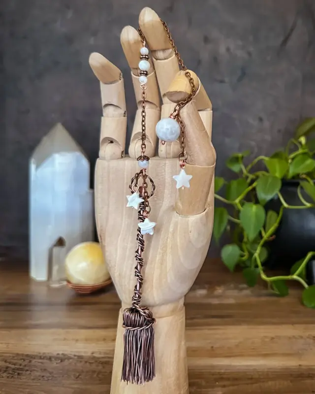 Crafted in copper with celestial accents, this broomstick pendulum supports dream work, moon rituals, and star-guided divination.

Each swing invites starlight and soul-knowing. Let this pendulum become your anchor in the vast, intuitive sea of the unseen.

Magickal Benefits: 
🌙 Moonstone, Abalone & Mother of Pearl: Intuition, emotional balance, and connection to lunar energies. 

How It Can Be Used: 
✨ Divination and dowsing 
✨ Clearing blocked energy 
✨ Reiki and energy healing 
✨ Space clearing and intention setting

This and many other creations to bring everyday magic to your life are available in the shop, link in bio 

#magicalcreations #magicalsolutions #makingmagic #makeeverydaymagic #magicaltools #divinationtools #ritualtools #pendulum #pendulummagic #herenchantedcreations #everydaywitchcraft #everydaymagic #basicwitch